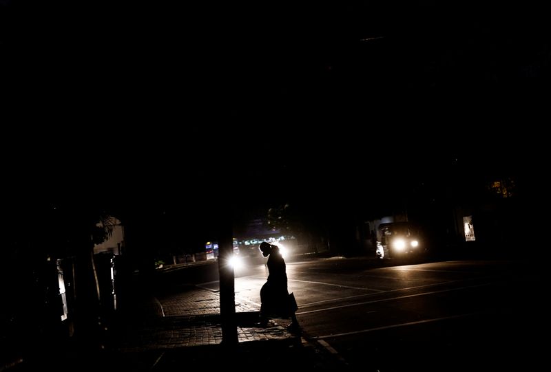 &copy; Reuters. A woman crosses a main road during a power cut due to fuel shortage, amid the country's economic crisis, in Colombo, Sri Lanka, June 16, 2022. REUTERS/Dinuka Liyanawatte/File Photo