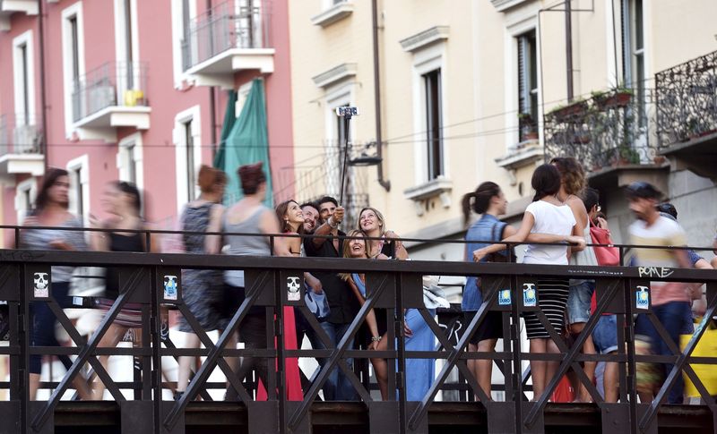 &copy; Reuters. FILE PHOTO: People take a selfie at Naviglio Gran Canal in Milan, August 29, 2015.  REUTERS/Flavio Lo Scalzo