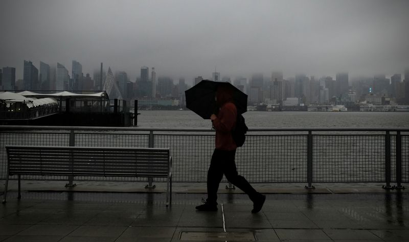 &copy; Reuters. FILE PHOTO: A man walks with an umbrella along the Hudson river waterfront in front of the Manhattan skyline as heavy rain moved into the northeast U.S. in Weehawken, New Jersey, U.S. October 26, 2021. REUTERS/Mike Segar    