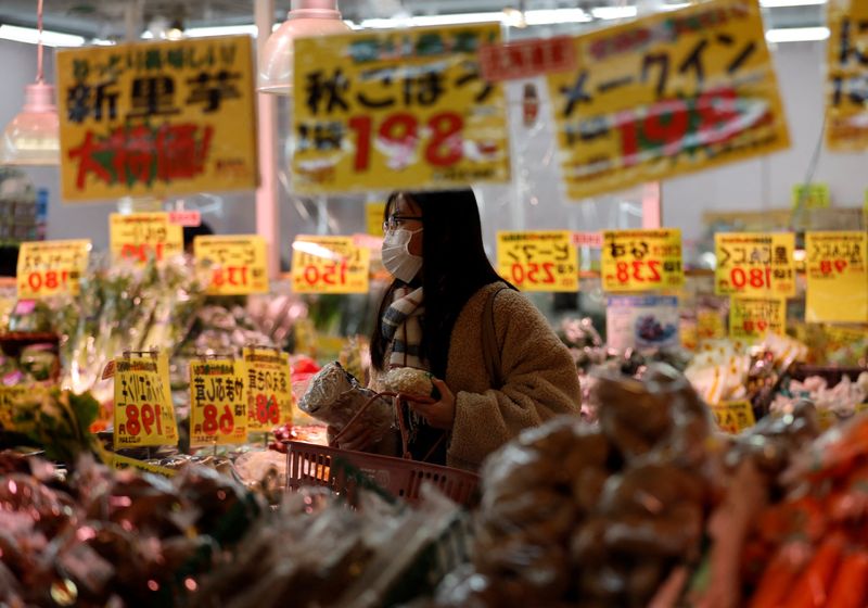 &copy; Reuters. FILE PHOTO: A shopper is reflected on a mirror glass as she checks food items at a supermarket in Tokyo, Japan January 20, 2023. REUTERS/Issei Kato