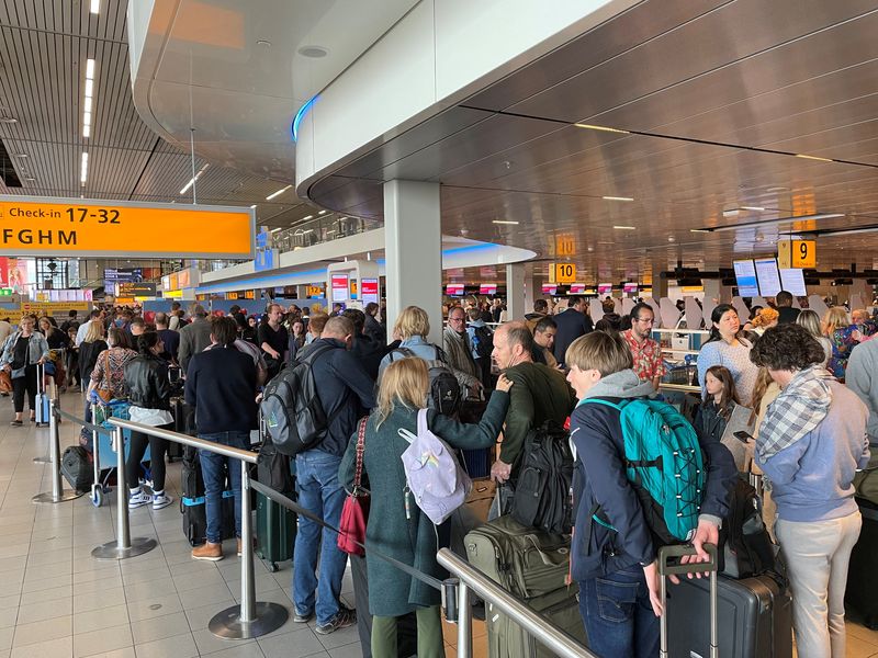 &copy; Reuters. FILE PHOTO: Travellers wait in lines at Amsterdam Schiphol Airport as an unannounced strike of ground staff caused many delays and cancellations, in Amsterdam, Netherlands April 23, 2022. REUTERS/Anthony Deutsch
