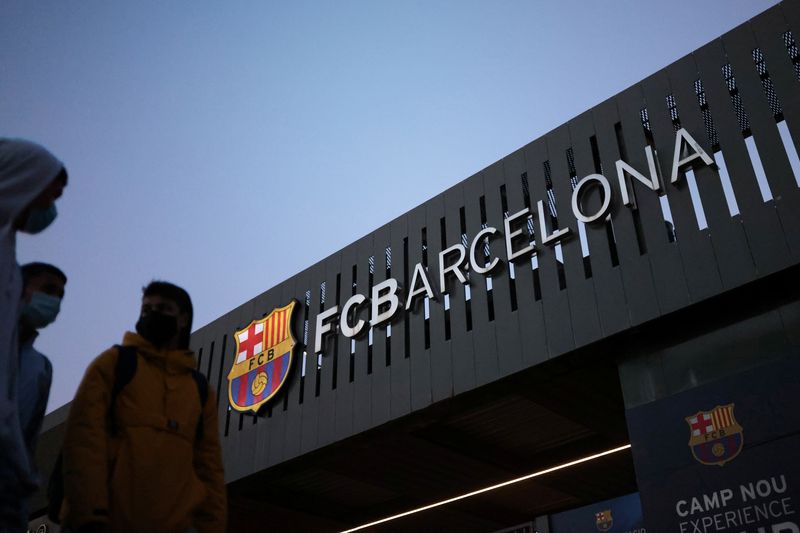 &copy; Reuters. FOTO ARCHIVO: Unas personas pasan junto al logotipo del club de fútbol Barcelona en el exterior del estadio Camp Nou en Barcelona, España, el 15 de enero de 2021. REUTERS/Nacho Doce