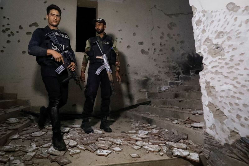 © Reuters. Police officers stand in the aftermath of an attack on a police station in Karachi, Pakistan February 17, 2023. REUTERS/Akhtar Soomro