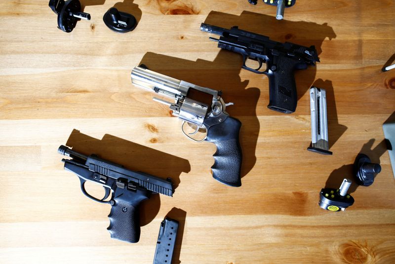 &copy; Reuters. FILE PHOTO: Three legally-owned hand guns are displayed on a gun owner's table after Canada's government introduced legislation to implement a "national freeze" on the sale and purchase of handguns, as a part of a gun control package that would also limit