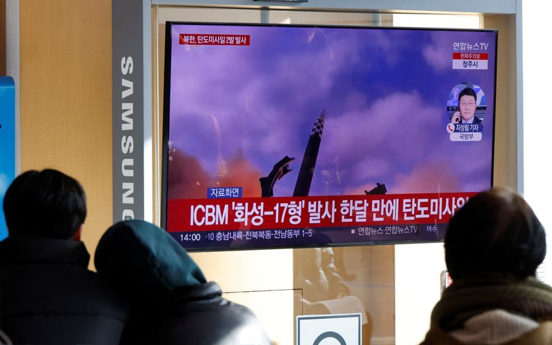 &copy; Reuters. 　２月１８日、 海上保安庁は北朝鮮から弾道ミサイルの可能性のあるものが発射されたと発表した。ミサイル発射の様子をテレビで見る人々、昨年１２月ソウルで撮影（２０２３年　ロイ