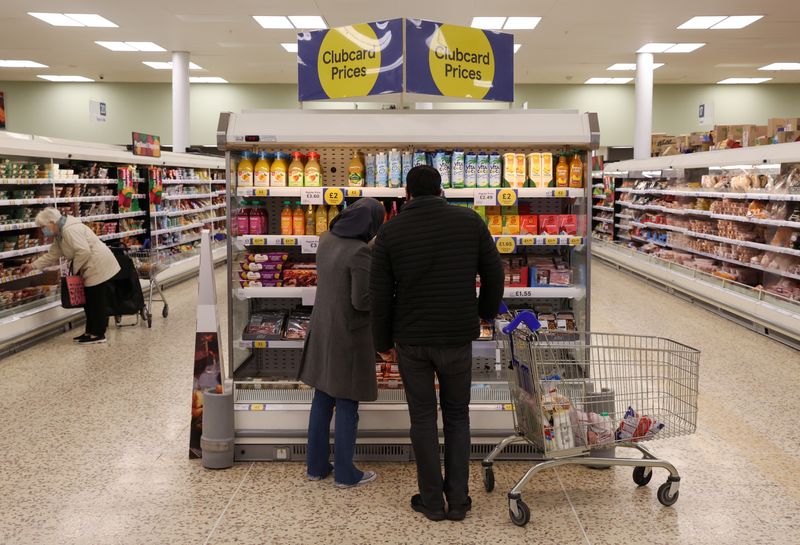 &copy; Reuters. FILE PHOTO: Shoppers walk next to the clubcard price branding inside a branch of a Tesco Extra Supermarket in London, Britain, February 10, 2022. REUTERS/Paul Childs