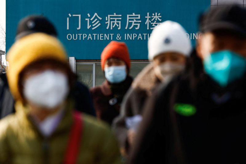 &copy; Reuters. أشخاص يضعون كمامات يسيرون بجانب مستشفى ببكين يوم 16 فبراير شباط 2023. تصوير: تينجشو وانغ - رويترز