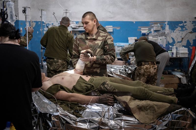 &copy; Reuters. Medics treat wounded Ukrainian soldiers inside a frontline medical stabilisation point, amid Russia's attack on Ukraine, near Vuhledar, Donetsk region, Ukraine, February 19, 2023. Nearly a year into Russia's invasion, fighting now amounts to attritional d