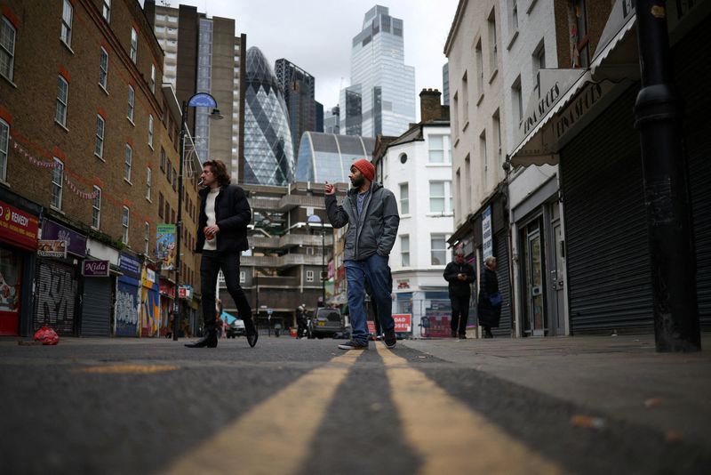 &copy; Reuters. FILE PHOTO: People walk past shops, with the City of London financial district in the background, in London, Britain, February 4, 2023. REUTERS/Henry Nicholls