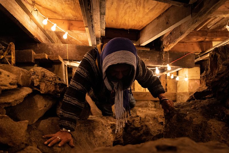 &copy; Reuters. FILE PHOTO: Ishmael Bermudez, an amateur archeologist, crawls on the bedrock that he exposed after digging under his house in the Brickell neighborhood in Miami, Florida, U.S., February 13, 2023. REUTERS/Marco Bello