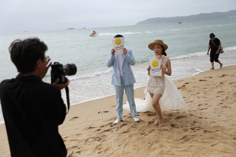 &copy; Reuters. FOTO DE ARCHIVO. Una pareja posa para las fotos durante una sesión de fotos de boda en la playa de Yalong Bay en Sanya, provincia de Hainan, China. 26 de noviembre de 2020. REUTERS/Tingshu Wang