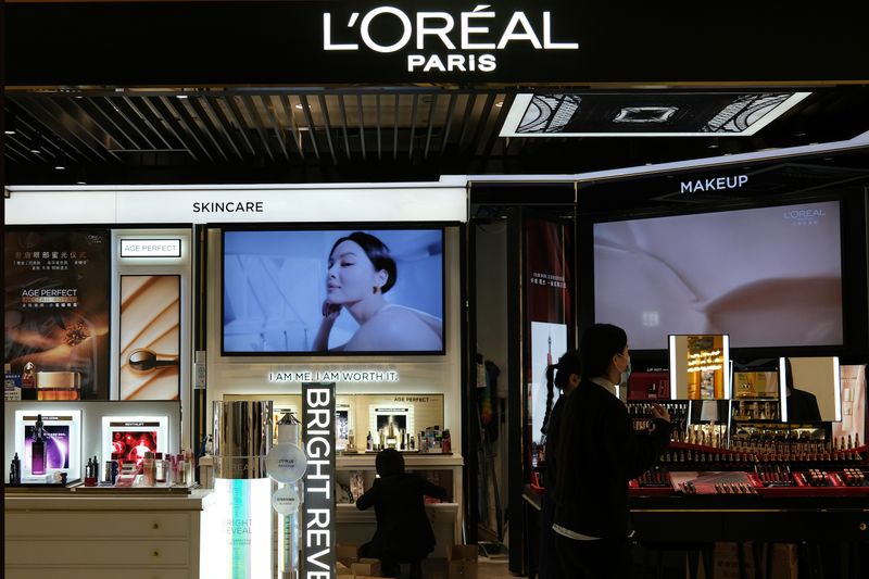 &copy; Reuters. FILE PHOTO: Staff members work at a counter of cosmetics brand L’Oreal at a shopping mall in Beijing, China November 18, 2021. REUTERS/Tingshu Wang