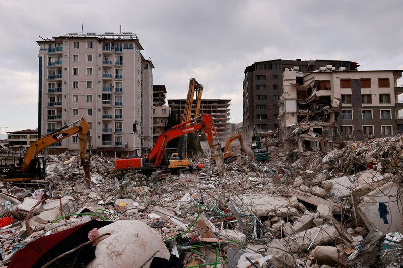 © Reuters. Workers clean the rubble of a collapsed building in the aftermath of a deadly earthquake in Antakya, Hatay province, Turkey, February 21, 2023. REUTERS/Thaier Al-Sudani