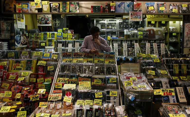 &copy; Reuters. FILE PHOTO: A shopkeeper uses a smartphone in a food store at a shopping district in Tokyo October 24, 2013. REUTERS/Yuya Shino