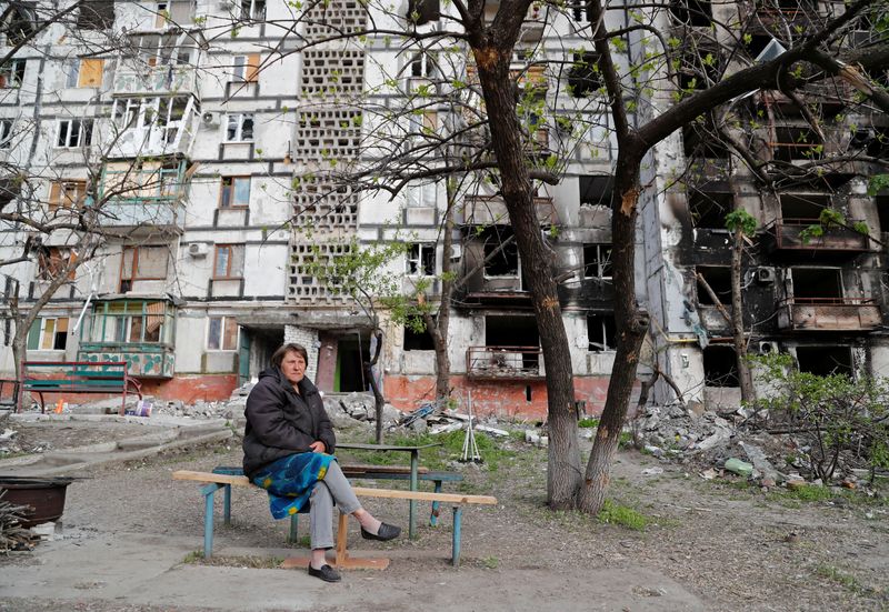 &copy; Reuters. FILE PHOTO: Local resident Tatiana Bushlanova sits on a bench near an apartment building heavily damaged during Ukraine-Russia conflict in the southern port city of Mariupol, Ukraine May 2, 2022. REUTERS/Alexander Ermochenko