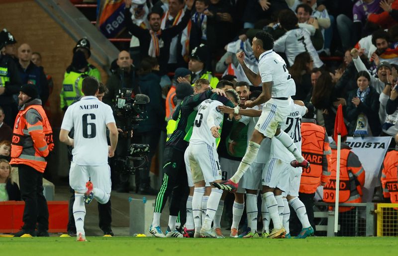 &copy; Reuters. Varios jugadores del Real Madrid celebran el quinto gol del equipo marcado por el francés Karim Benzema en su partido de octavos de final de la Liga de Campeones disputado contra el Liverpool en el estadio de Anfield, Reino Unido, el 21 de febrero de 202