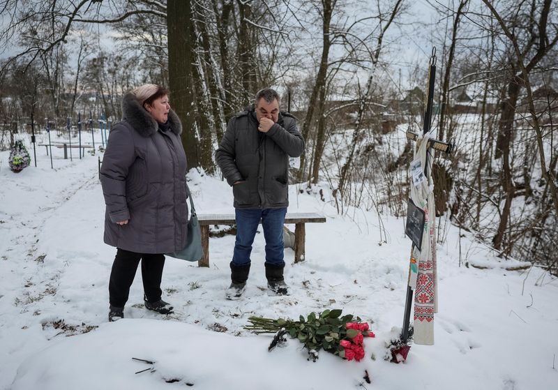 &copy; Reuters. Svitlana Safonova, 60, visit the grave of her sister Iryna Filkina, 52, along with Iryna's partner Anatoliy Shchyruk in Bucha, outside of Kyiv, Ukraine February 7, 2023. REUTERS/Gleb Garanich