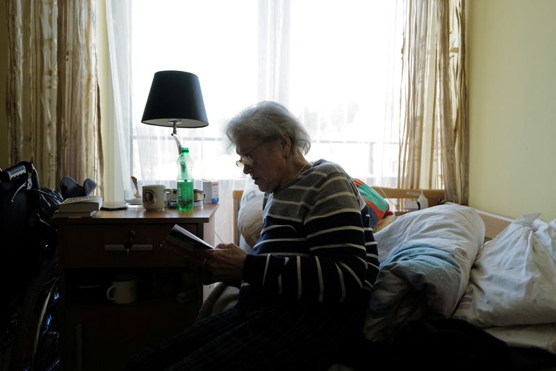 &copy; Reuters. Ukrainian refugee Tamila Melnichenko, 82, from Kyiv, reads a book in her room at the Armada retirement home in Glogoczow, Poland February 10, 2023. A year ago, she was uprooted by the Russian invasion and now spends her days in the retirement home, longi