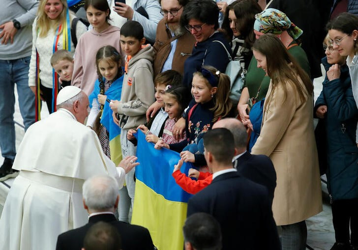 &copy; Reuters. El Papa Francisco saluda a varios niños con una bandera de Ucrania durante su audiencia general semanal en el Vaticano. 22 febrero 2023. REUTERS/Remo Casilli