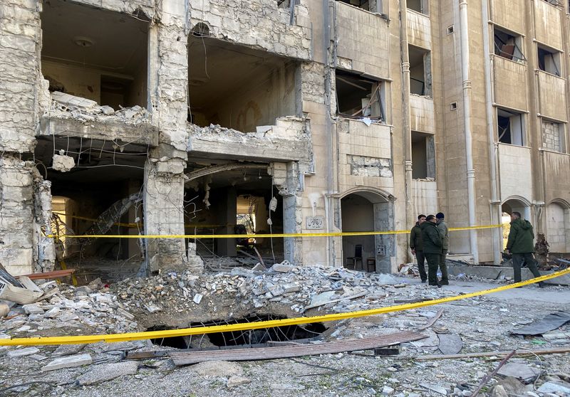 © Reuters. أفراد من الشرطة يقفون بالقرب من مبنى مدمر في موقع هجوم صاروخي في حي كفر سوسة بدمشق يوم 19 فبراير شباط 2023. تصوير: فراس مقدسي - رويترز.