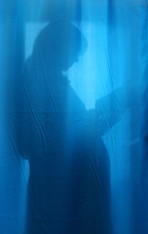 © Reuters. FILE PHOTO: A pregnant woman is seen through the curtain at a maternity hospital in the Ukrainian capital Kyiv, October 31, 2004. REUTERS/Mykhailo Markiv