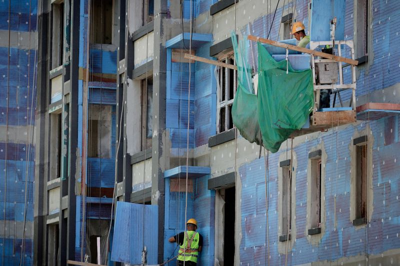 &copy; Reuters. FILE PHOTO: Men work at a construction site of apartment buildings in Beijing, China, July 15, 2022. REUTERS/Thomas Peter