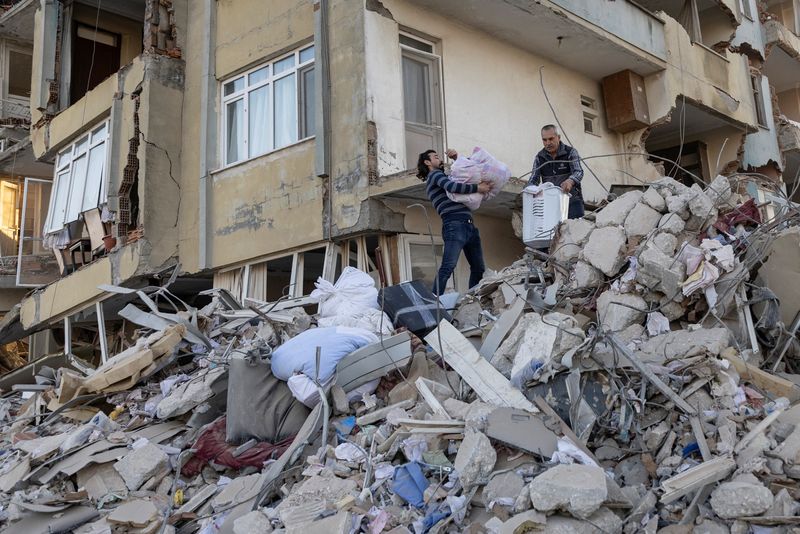 &copy; Reuters. Arsin y su padre sacan pertenencias de su apartamento destruido tras el terremoto en Antioquía, provincia de Hatay, Turquía, 20 de febrero de 2023. REUTERS/Eloisa Lopezh