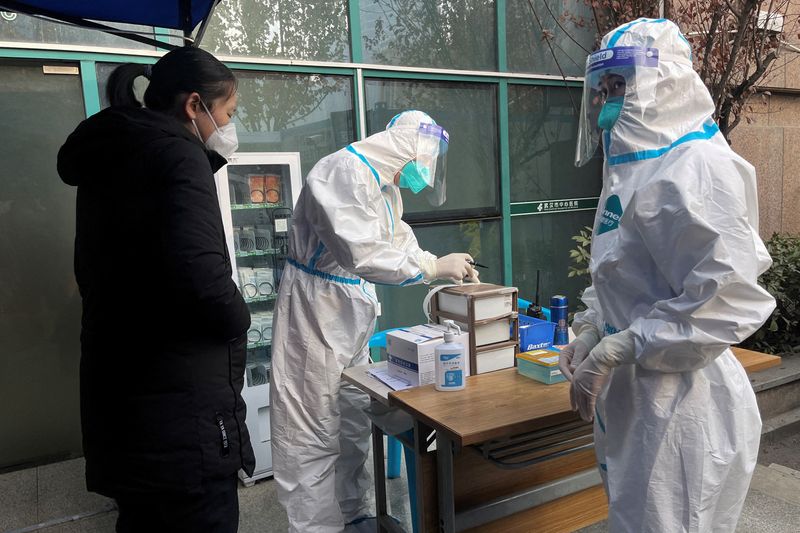 &copy; Reuters. Profissionais de saúde em trajes de proteção registram informações de paciente em hospital em Wuhan, na China
31/12/2022 REUTERS/Tingshu Wang