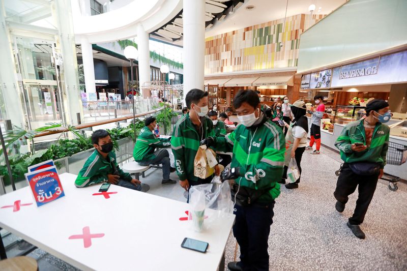 &copy; Reuters. FILE PHOTO: Staff of Grab, a food delivery service company, wait for orders inside the Central World mall in Bangkok, Thailand, March 22, 2020. REUTERS/Soe Zeya Tun