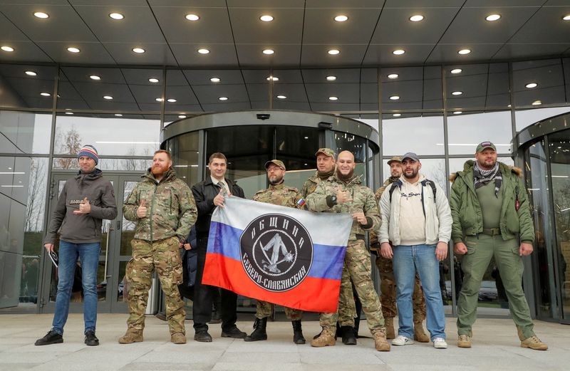 &copy; Reuters. Des visiteurs posent pour une photo à l'extérieur du Centre PMC Wagner, qui est un projet mis en œuvre par l'homme d'affaires et fondateur du groupe militaire privé Wagner, Yevgeny Prigozhin, lors de l'ouverture officielle du bloc de bureaux à Saint 