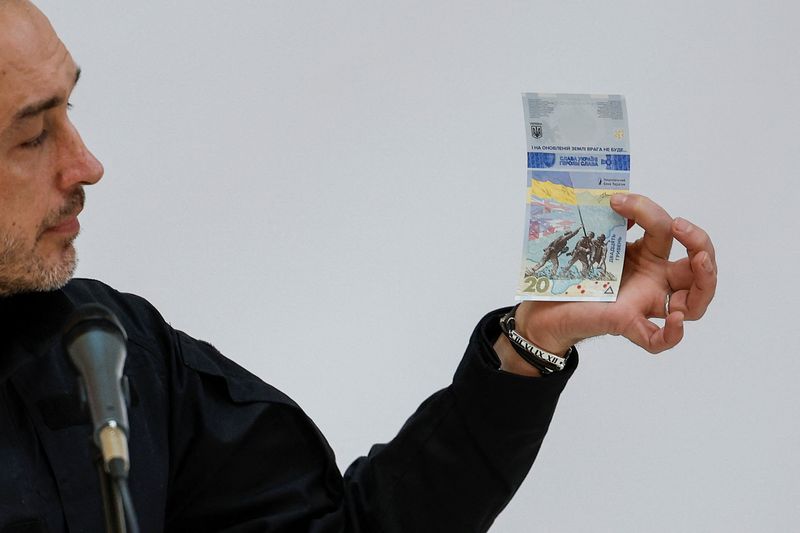 &copy; Reuters. محافظ البنك الوطني الأوكراني أندريه بيشني خلال عرض تقديمي بالبنك المركزي في كييف وهو يمسك الورقة النقدية الجديدة يوم الخميس. تصوير: فالنتين