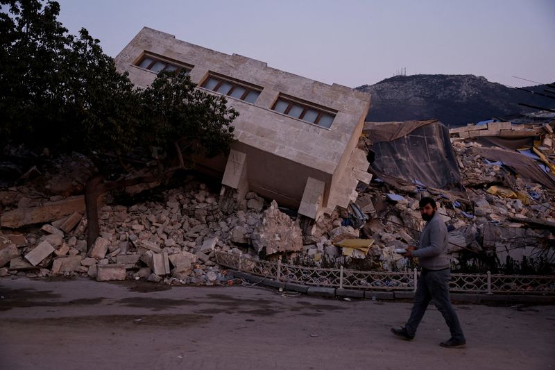 &copy; Reuters. شخص يسير بالقرب من مبني منهار جراء زلزال مدمر بمدينة أنطاكية في تركيا يوم 21 فبراير شباط 2023. تصوير: كلودا كيلكوين – رويترز.