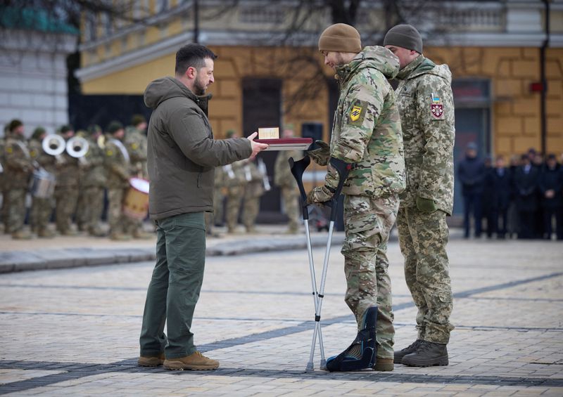 &copy; Reuters. الرئيس الأوكراني فولوديمير زيلينسكي يمنح ميدالية لجندي يستخدم عكازين خلال احتفال مخصص لإحياء الذكرى الأولى للغزو الروسي أقيم في كييف يوم ا