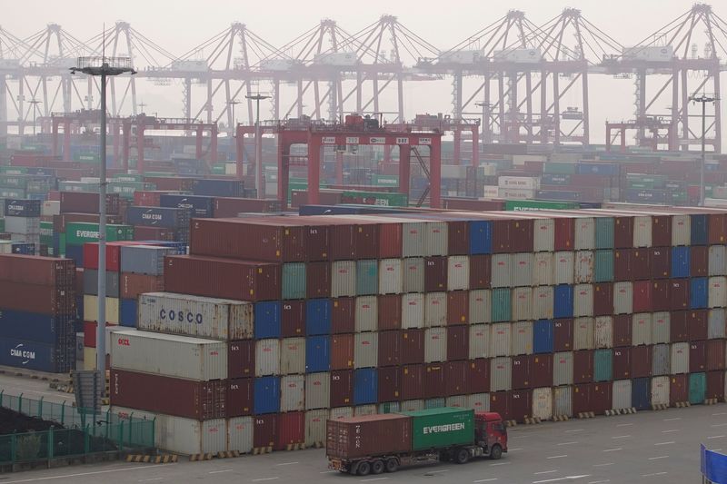 &copy; Reuters. Caminhão diante de contêineres em porto em Xangai 
13/01/2022
REUTERS/Aly Song