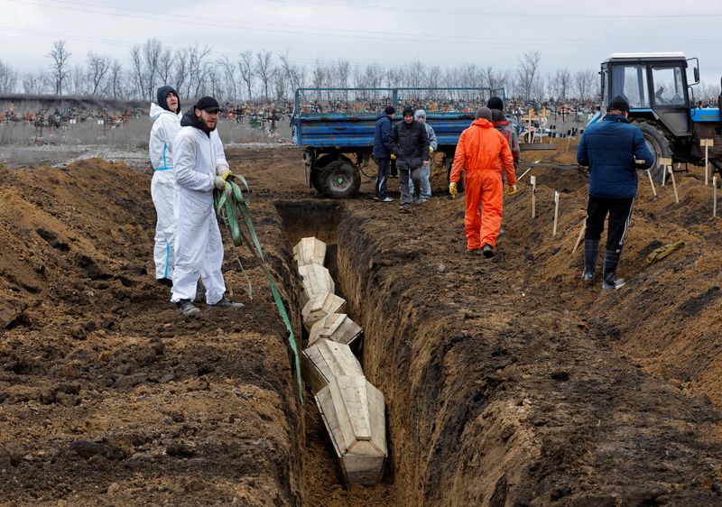 &copy; Reuters. Trabalhadores posicionam caixões em Mariupol, território ucraniano controlado pela Rússia
4/02/2023
REUTERS/Alexander Ermochenko/File Photo