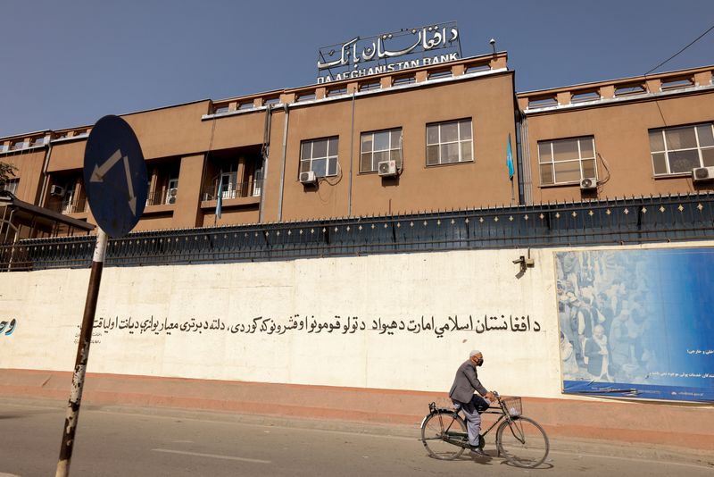 &copy; Reuters. FILE PHOTO: A man rides a bike in front of the Bank of Afghanistan in Kabul, Afghanistan October 8, 2021. REUTERS/Jorge Silva