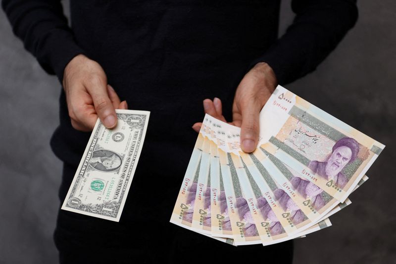 &copy; Reuters. FILE PHOTO: A currency dealer poses for a photo with a U.S one dollar bill and the amount being given when converting it into Iranian rials in an exchange shop in Tehran, Iran December 25, 2022. Majid Asgaripour/WANA (West Asia News Agency) via REUTERS 