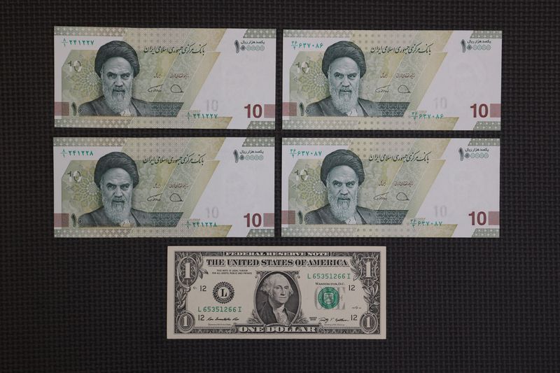 &copy; Reuters. عملة نقدية من فئة دولار أمريكي واحد إلى جانب أربع عملات نقدية من فئة 10000 ريال إيراني داخل متجر للصرافة بطهران في 25 ديسمبر كانون الأول 2022. صورة