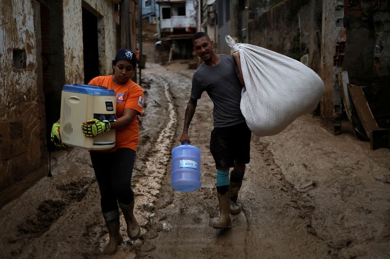 &copy; Reuters. Homem carrega doações recebidas acompanhado por voluntário durante operações de socorro a vítimas de deslizamentos de terra em São Sebastiao, Brasil
23/02/2023
Reuters/Roosevelt Cassio