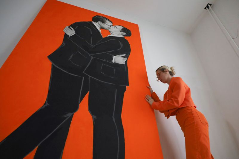 &copy; Reuters. Kosovo artists Ermira Murati stands near her paiting of Kosovo Prime Minister Albin Kurti and Serbian President Aleksandar Vucic giving each other a kiss on the lips, in an art gallery, in Pristina, Kosovo, February 25, 2023. REUTERS/Fatos Bytyci
