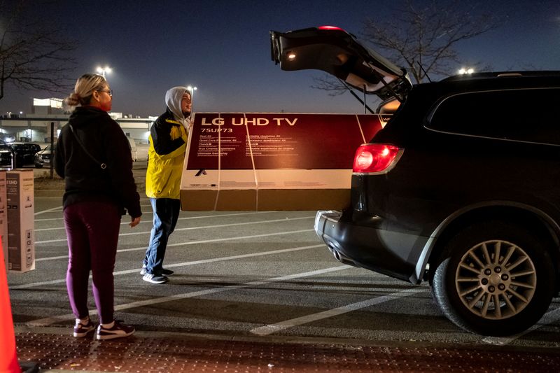 &copy; Reuters. FOTO DE ARCHIVO: Compradores cargan un televisor en su coche fuera de una tienda Best Buy durante las ventas del Viernes Negro en Chicago, Illinois, Estados Unidos, 25 de noviembre de 2022. REUTERS/Jim Vondruska