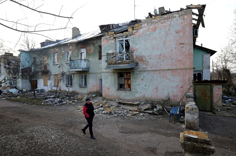 &copy; Reuters. Svitlana Gynzhul caminha em frente a casa destruída em Luch, na Ucrânia
25/02/2023 REUTERS/Lisi Niesner