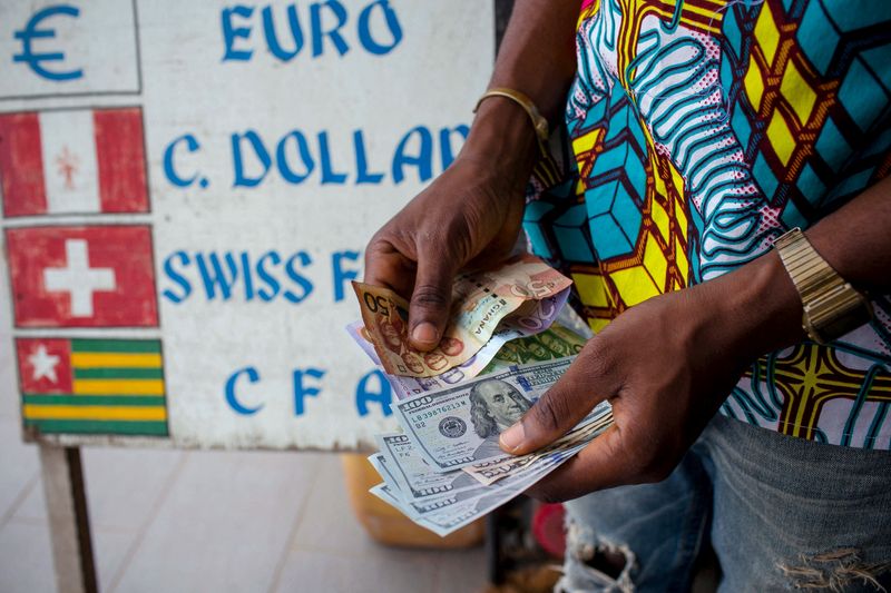 &copy; Reuters. FILE PHOTO: A man trades U.S. dollars for Ghanaian cedis at a currency exchange office in Accra, Ghana, June 15, 2015. Picture taken June 15.  REUTERS/Francis Kokoroko