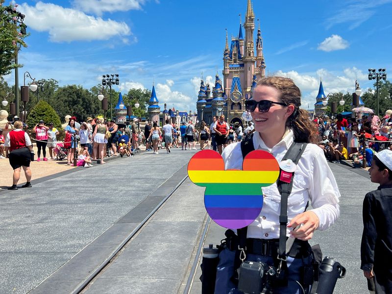 © Reuters. Fotógrafa do Walt Disney World segura um recorte do Mickey Mouse com as cores do arco-íris antes do desfile 