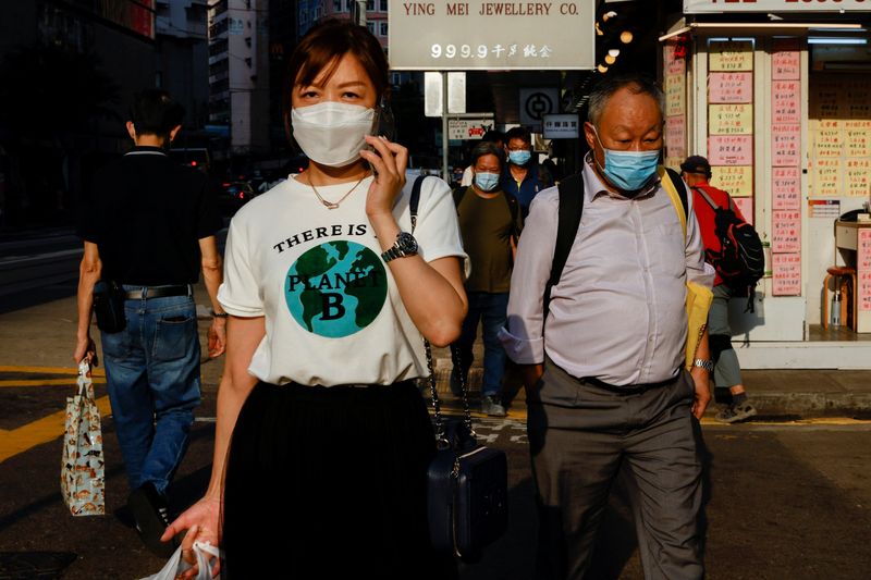 &copy; Reuters. FILE PHOTO: People wearing face masks walk through Wan Chai during the coronavirus disease (COVID-19) pandemic in Hong Kong, China, April 14, 2022. REUTERS/Tyrone Siu