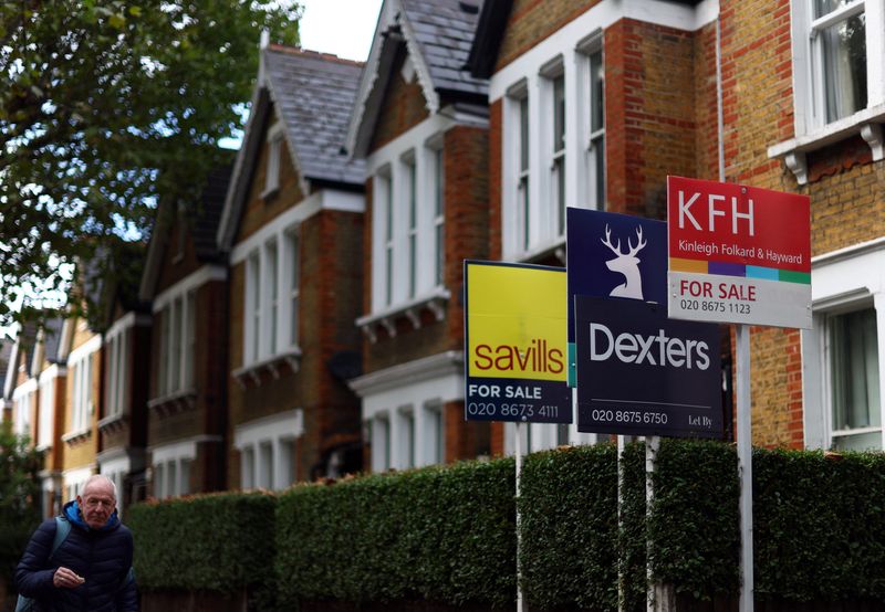 &copy; Reuters. FILE PHOTO: A man walks past houses ‘For Sale’ in a residential street in London, Britain, September 27, 2022. REUTERS/Hannah McKay