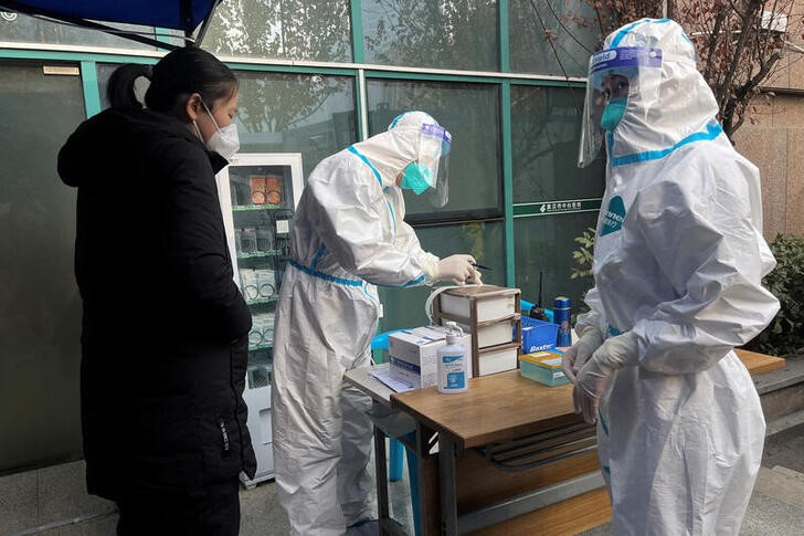 &copy; Reuters. Imagen de archivo de trabajadores sanitarios registrando información a la entrada de una clínica en el Hospital Central de Wuhan, China. 31 diciembre 2022. REUTERS/Tingshu Wang