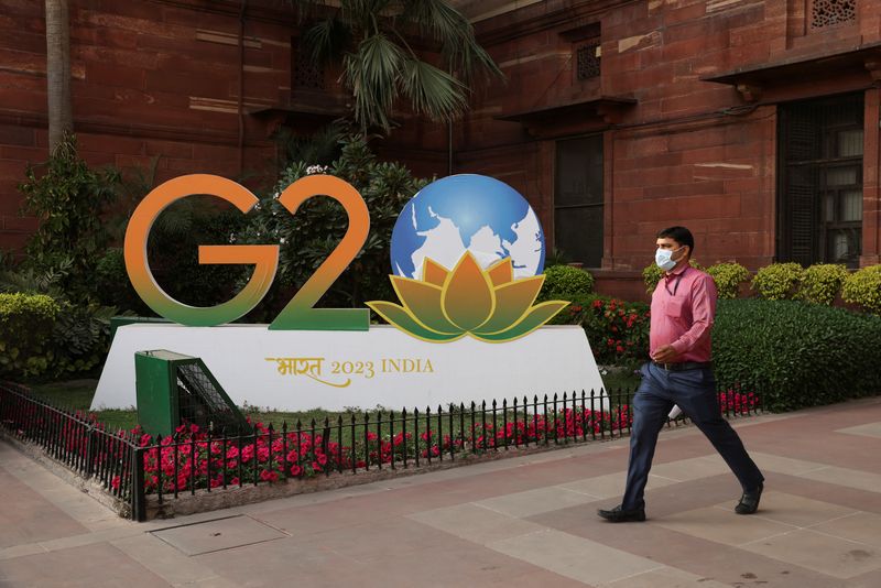 © Reuters. A man walks past a model of G20 logo outside the finance ministry in New Delhi, India, March 1, 2023. REUTERS/Anushree Fadnavis