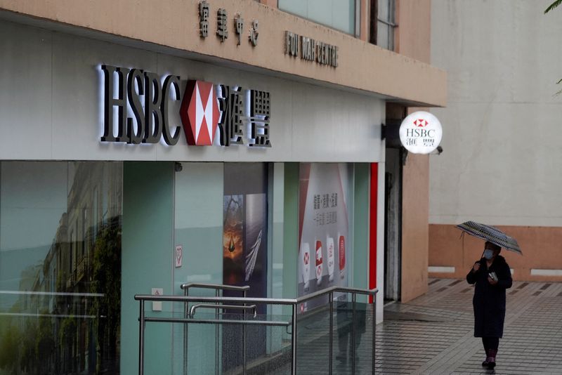 &copy; Reuters. FILE PHOTO: A pedestrian wearing a face mask following the coronavirus disease (COVID-19) outbreak, walks past a HSBC bank branch in Hong Kong, China February 22, 2022. REUTERS/Lam Yik