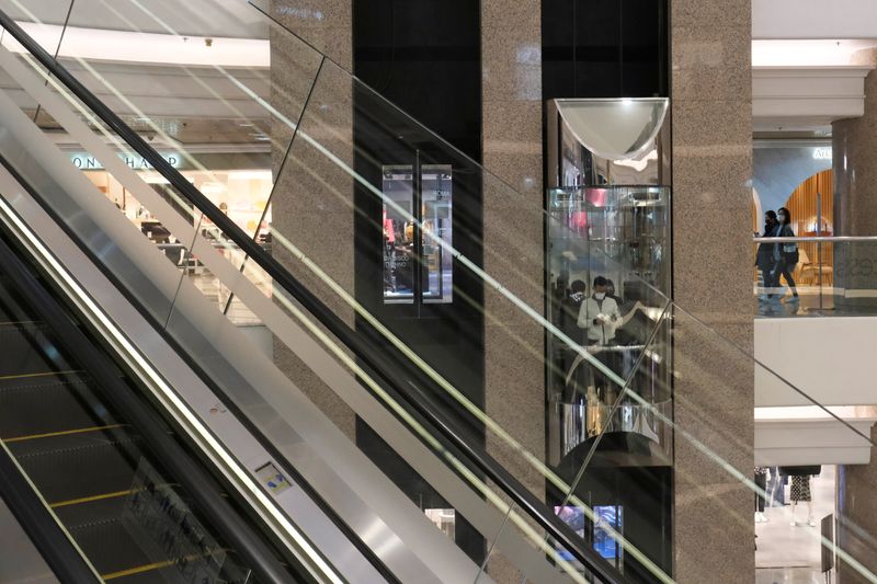 &copy; Reuters. FILE PHOTO: People wearing protective masks ride a lift at Times Square shopping centre, following the outbreak of the new coronavirus, in Hong Kong, China February 21, 2020. REUTERS/Tyrone Siu